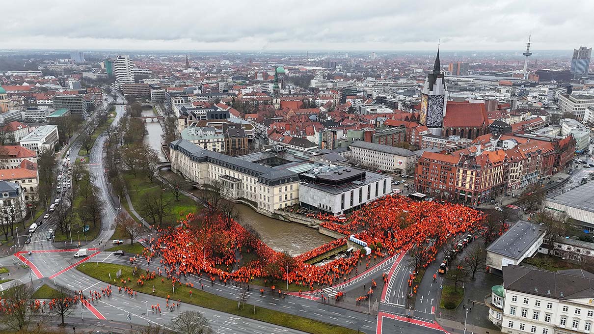 Drohnenaufnahme von einer Menschenmenge bei einer Demonstration von Jägerinnen und Jägern in Hannover. Alle tragen orangefarbene Kleidung.